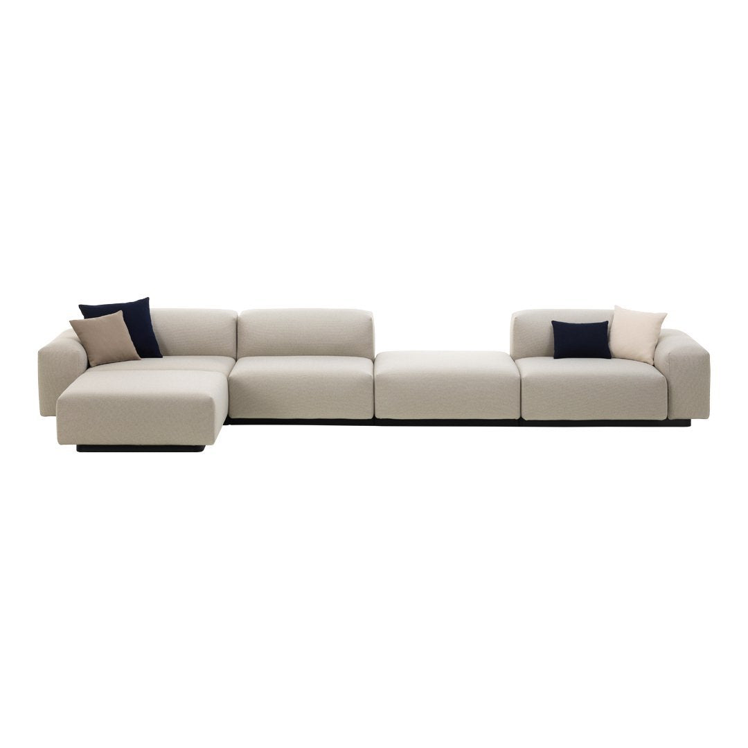 Light beige sectional sofa with navy and blush accent pillows, featuring a sleek, modern design and no patterns.