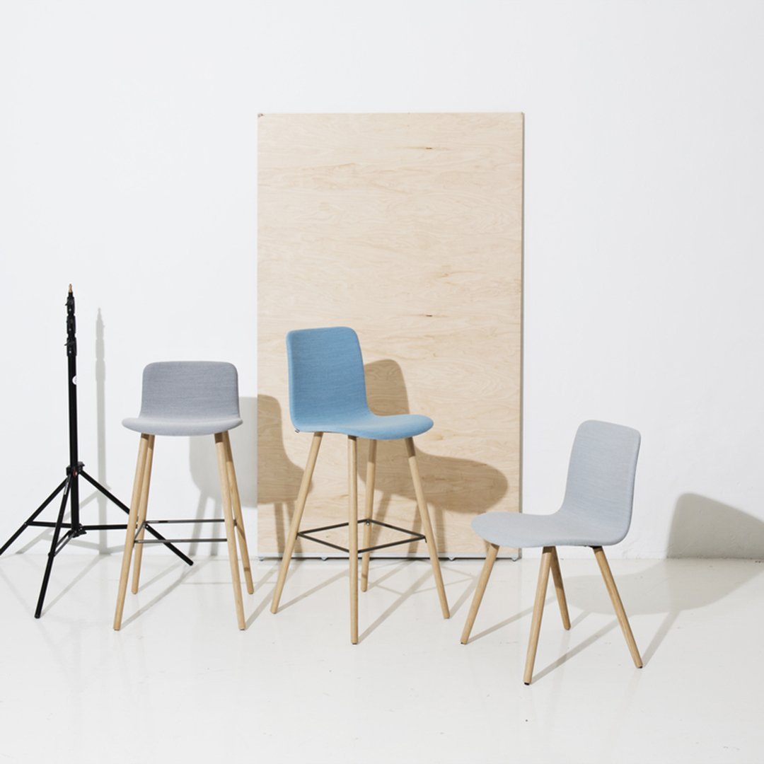 Set of modern chairs in light blue and gray, featuring sleek designs and wooden legs against a neutral backdrop.