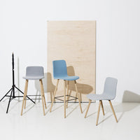 Set of modern chairs in light blue and gray, featuring sleek designs and wooden legs against a neutral backdrop.