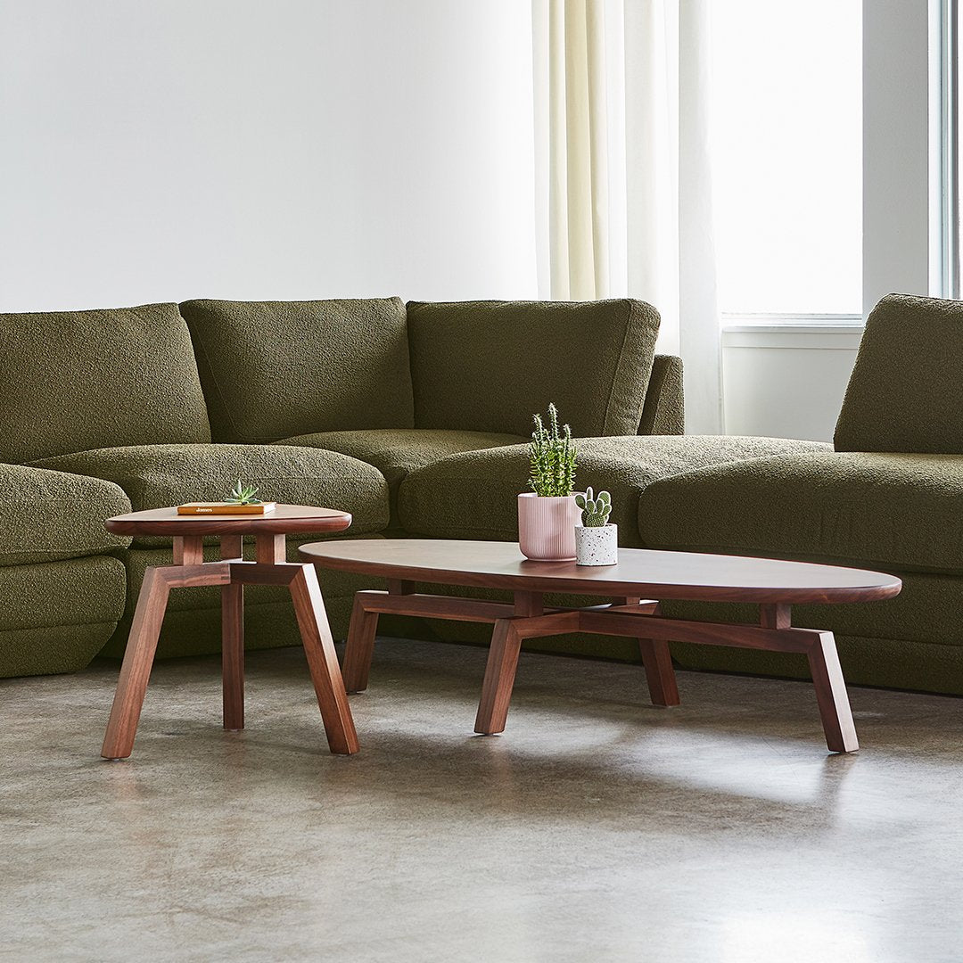 Wooden coffee tables in rich brown with a smooth finish, paired with an olive-green sectional sofa.