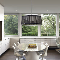Modern black striped pendant light in a bright kitchen with white cabinetry and a round glass dining table.