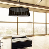 Black patterned pendant light hanging in a modern setting with large windows and minimalist decor.