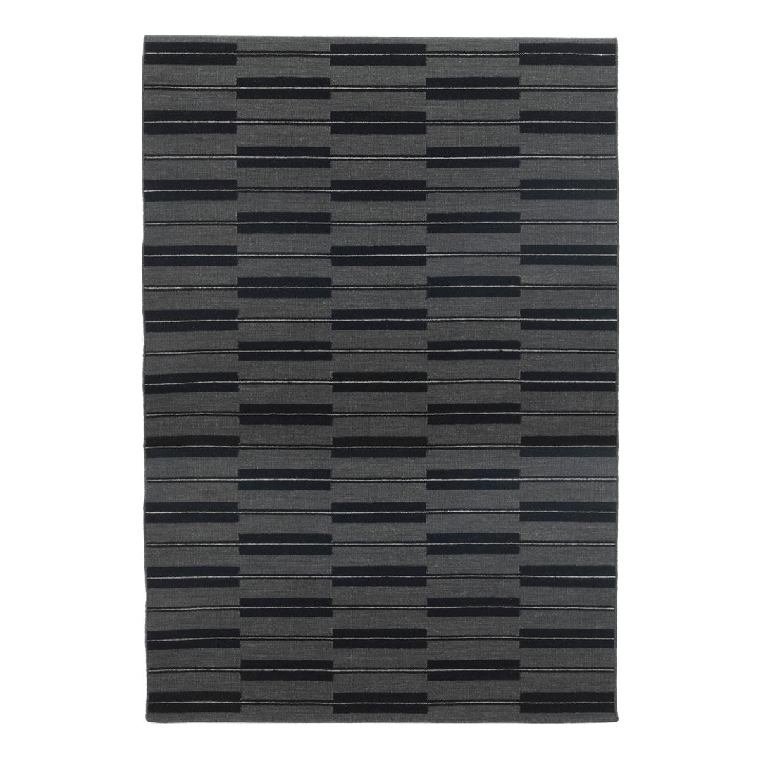 Gray area rug featuring a modern striped pattern in varying shades of charcoal and black. Ideal for stylish decor.