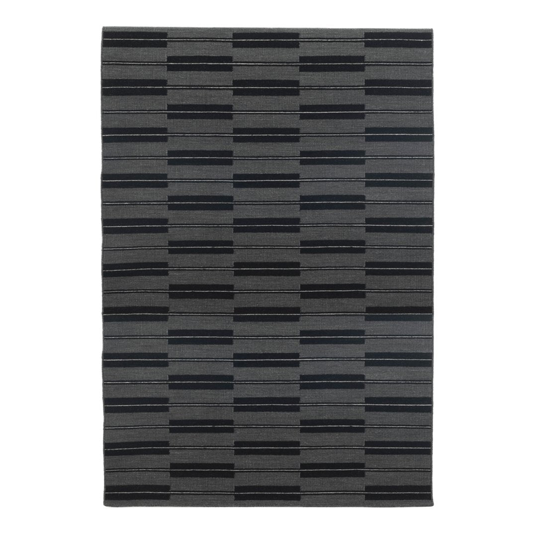 Gray area rug featuring a modern striped pattern in varying shades of black and charcoal. Perfect for contemporary spaces.