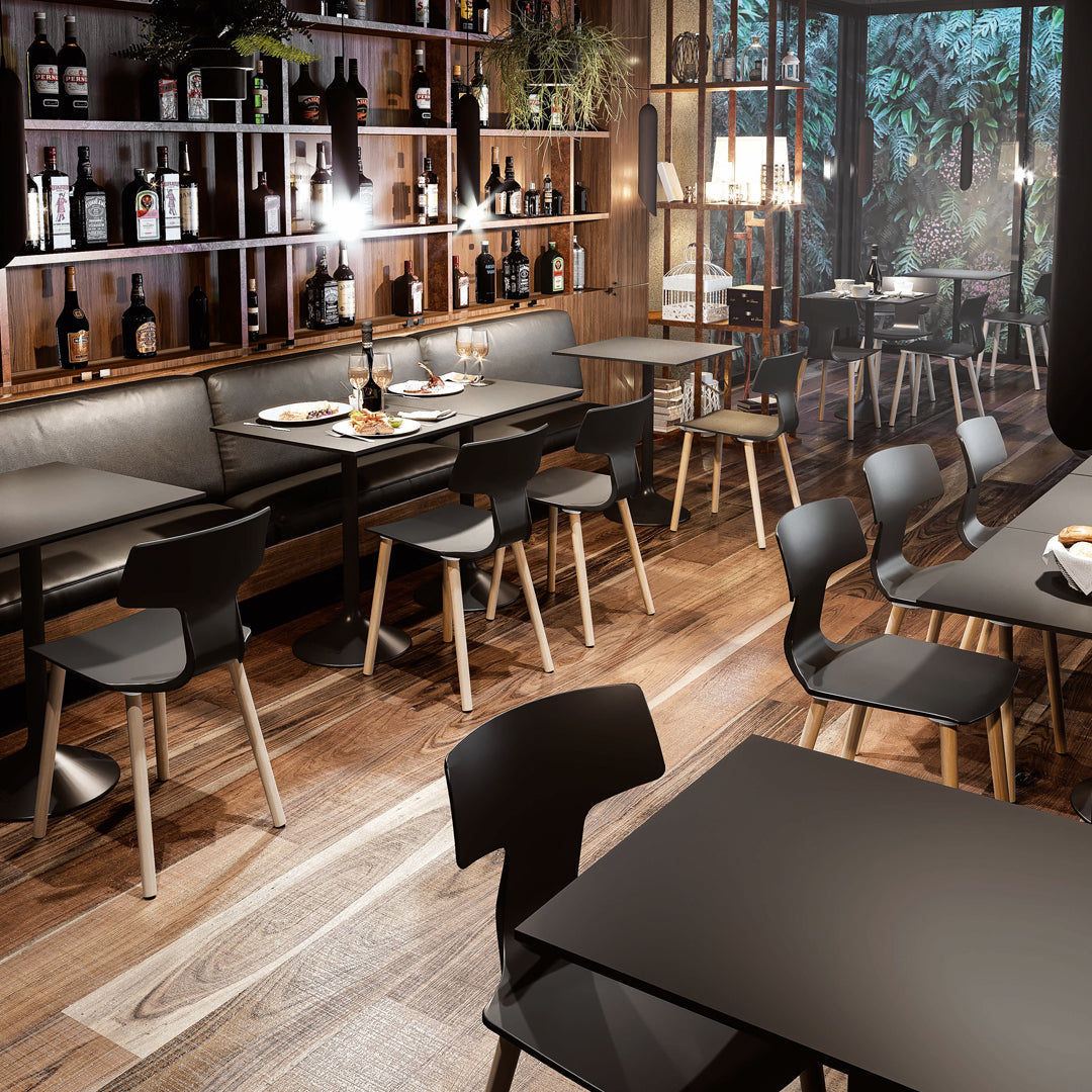 "Modern dining area featuring black furniture, warm wood tones, and natural greenery accents in a stylish setting."