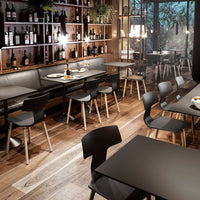 "Modern dining area featuring black furniture, warm wood tones, and natural greenery accents in a stylish setting."