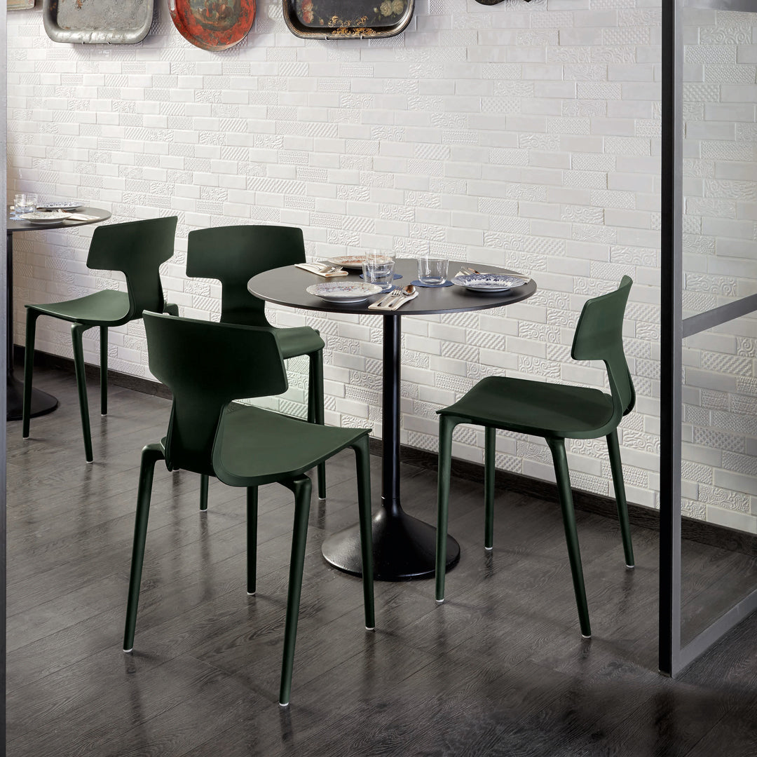 Green dining chairs with sleek lines around a black table in a modern dining space. Elegant and minimalistic design.