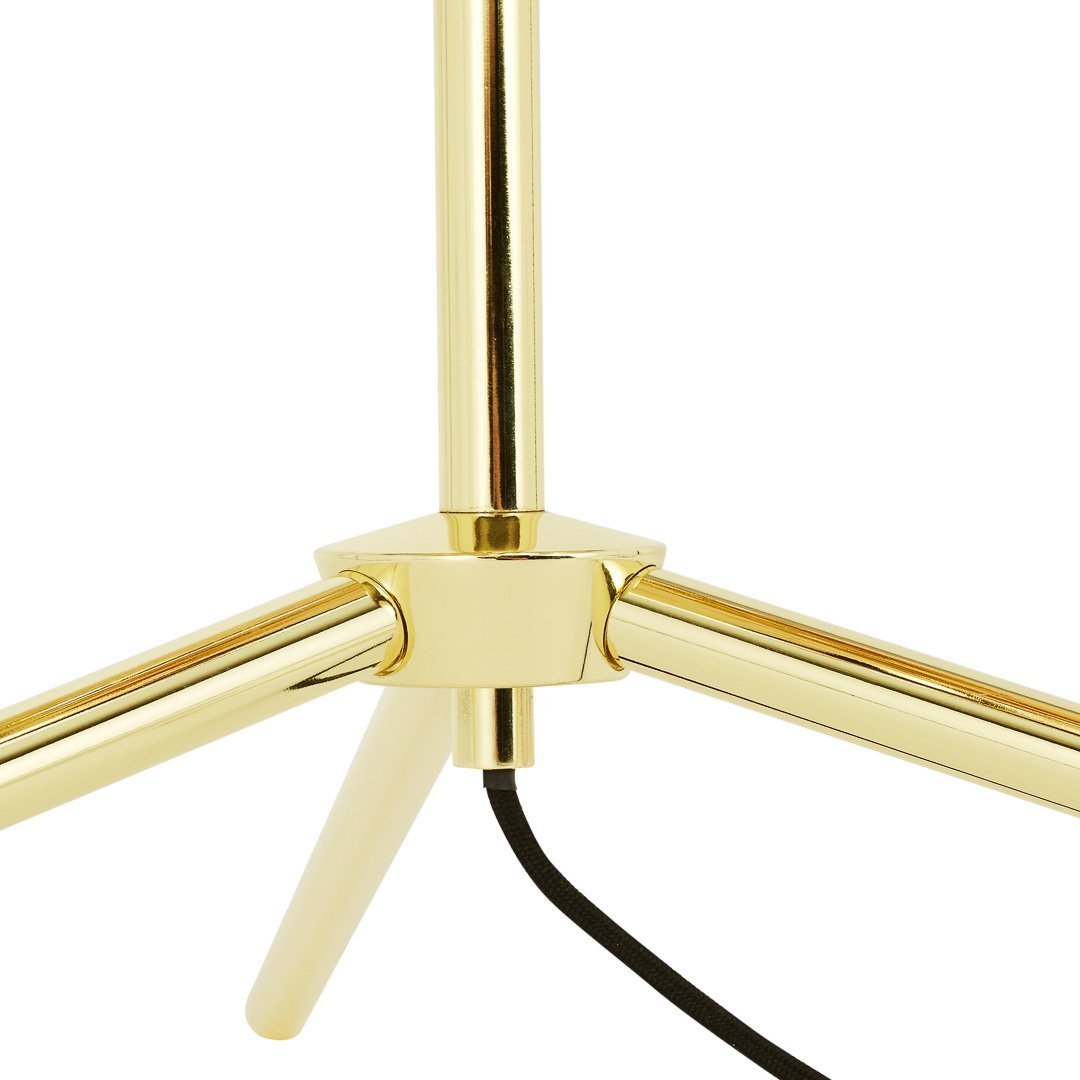 Gold tripod lamp base with a sleek, shiny finish and contrasting black cable. Modern and stylish design elements.