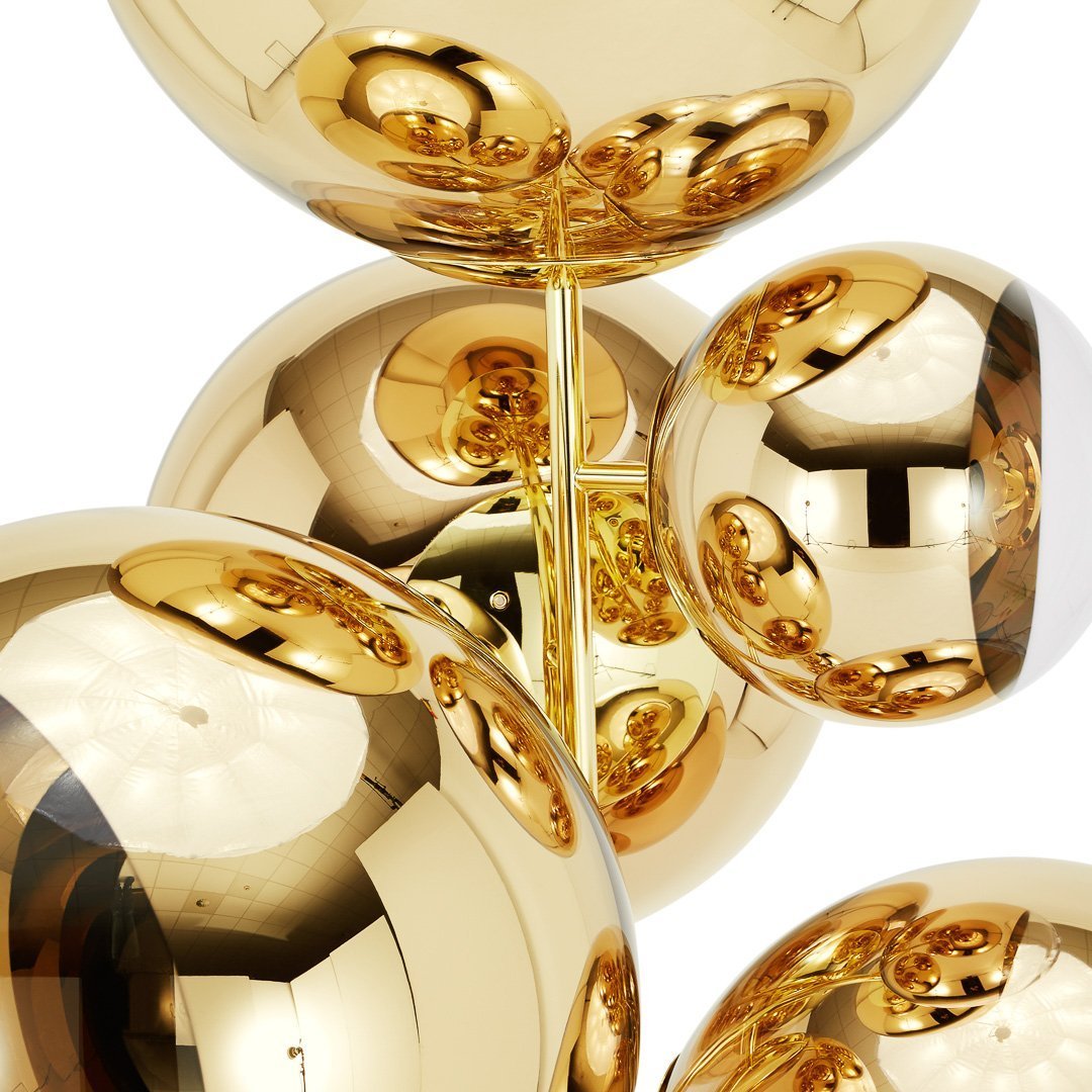 Shiny gold spheres with reflective surfaces, showcasing a glossy finish and modern design against a white background.