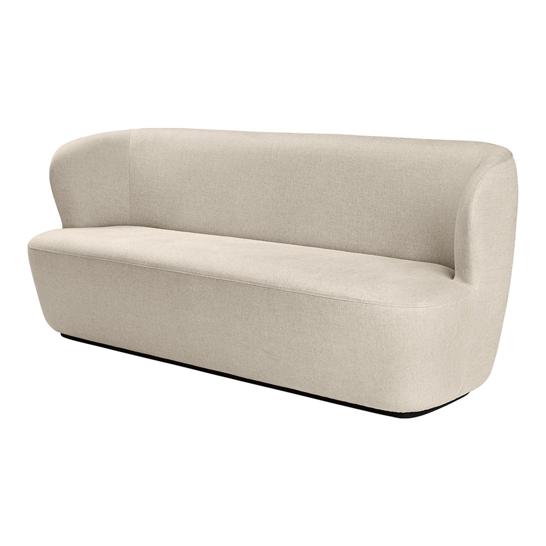 Beige upholstered sofa with a smooth, minimalist design and curved arms, featuring a solid, neutral color.