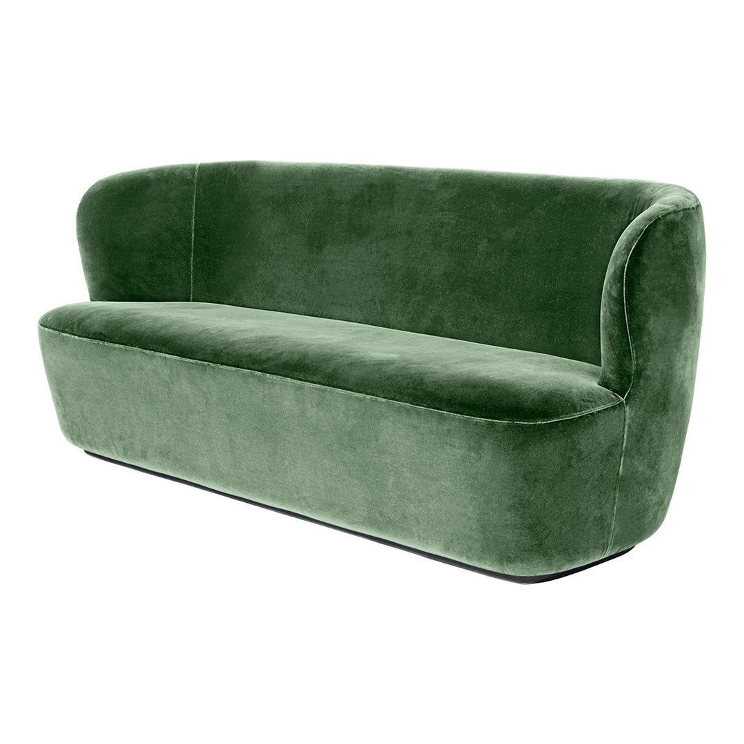 Soft green velvet sofa with a modern curved design, perfect for contemporary living spaces.