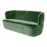 Soft green velvet sofa with a modern curved design, perfect for contemporary living spaces.