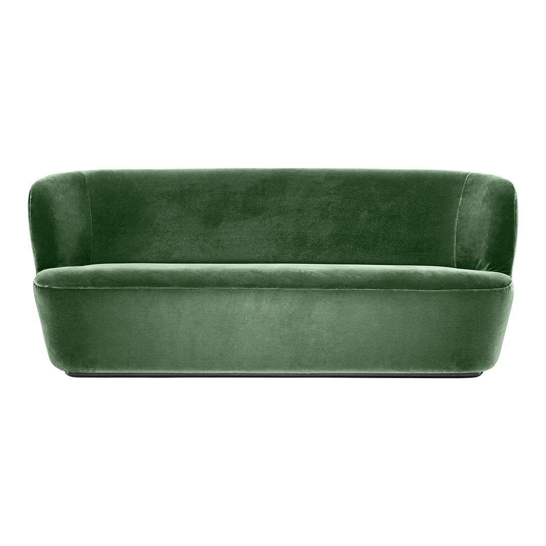 Velvet green sofa with a smooth, modern design and a rounded backrest, perfect for stylish living spaces.
