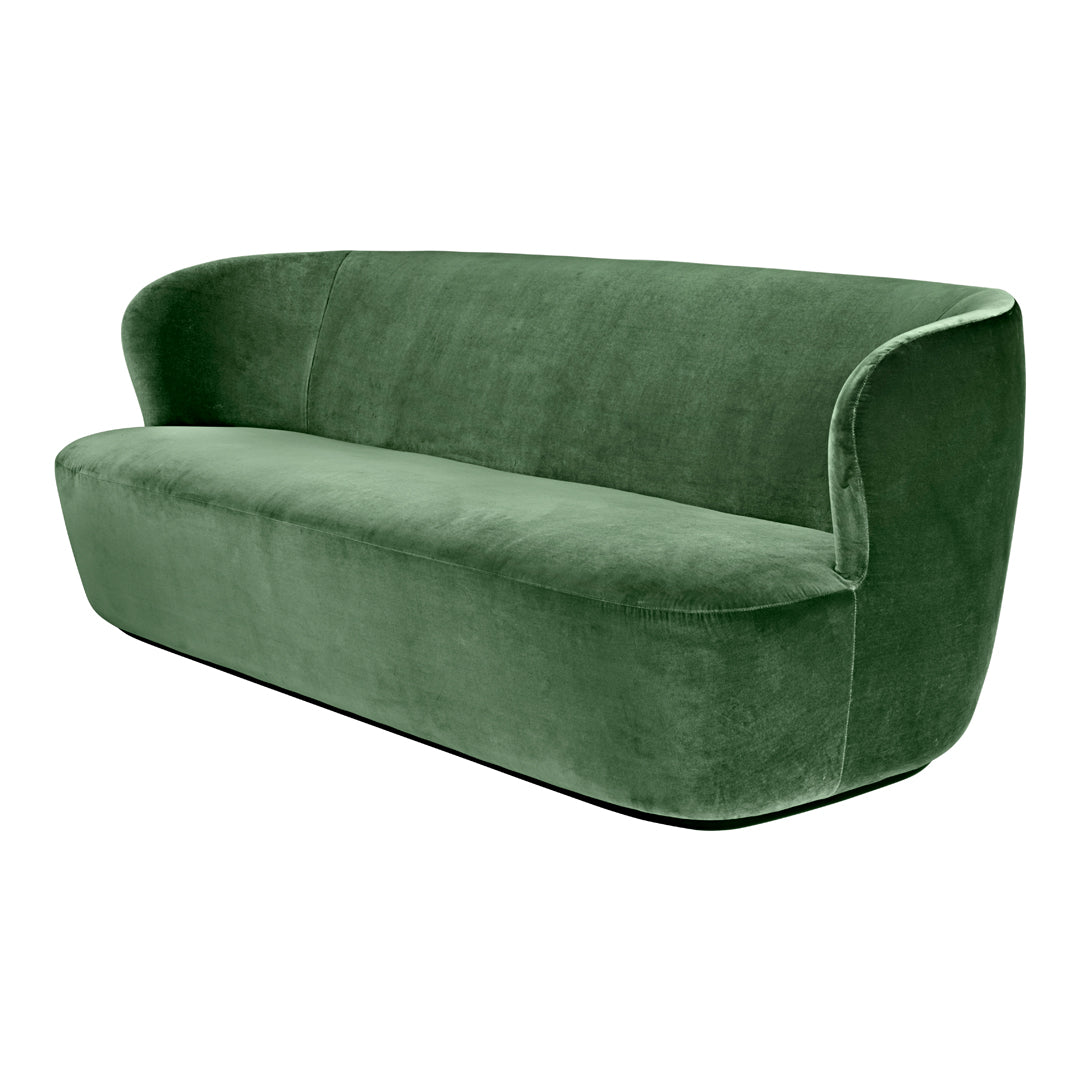 Velvet green couch with a smooth, curved design and no visible patterns, perfect for modern decor.