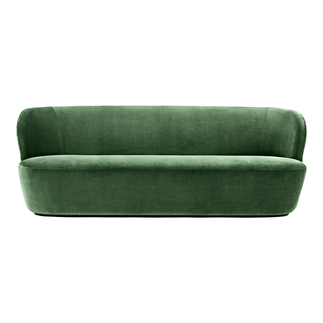 "Deep green velvet sofa with a smooth, solid color and modern, rounded design."