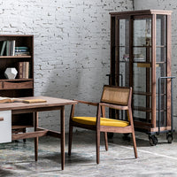 Mid-century modern furniture featuring warm wood tones, yellow upholstered chair, and clear glass cabinet with a sleek design.