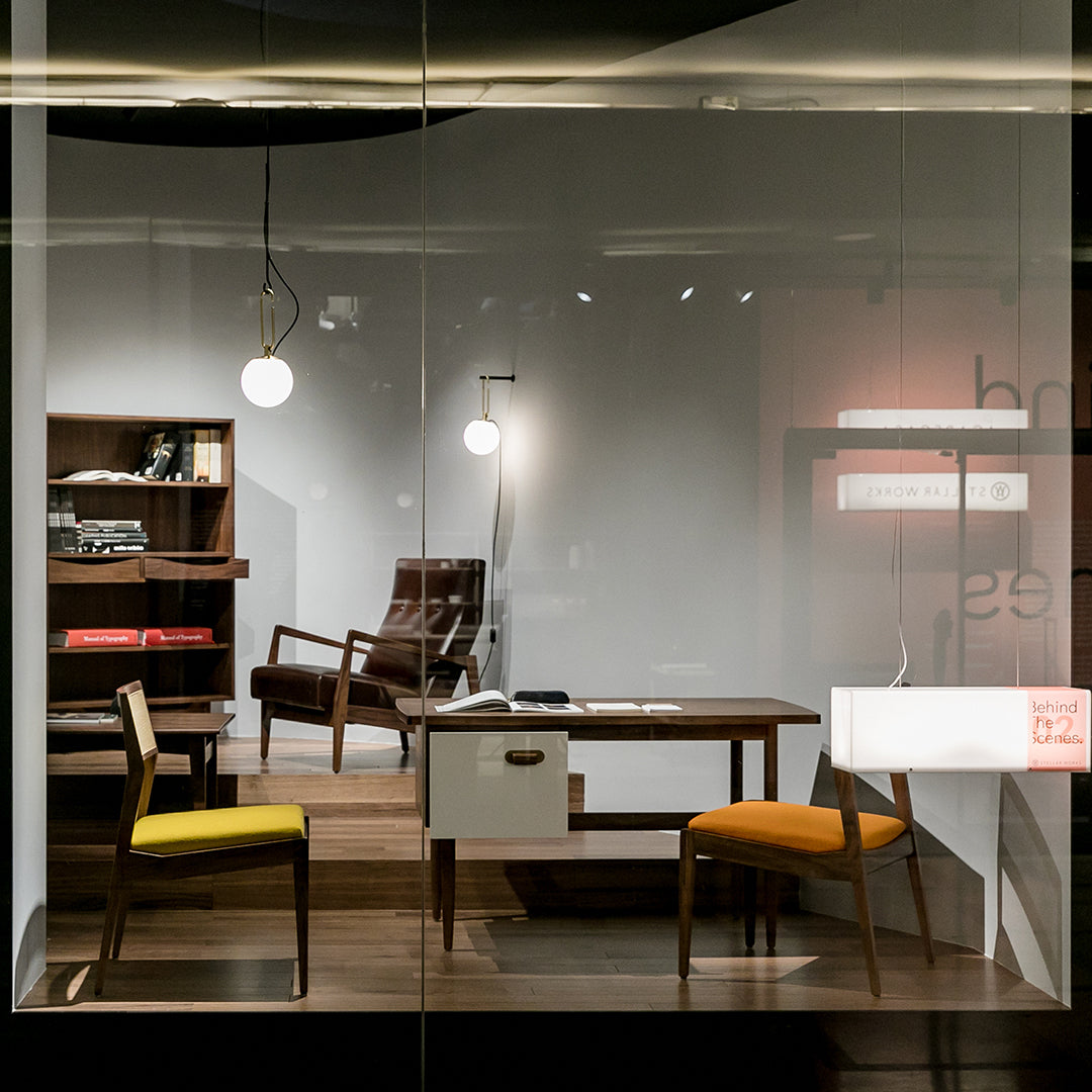 Chic modern office setup featuring yellow and orange chair accents, rich wood tones, and minimalist decor.
