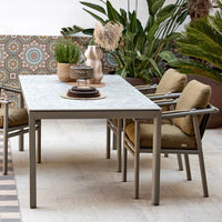 "Stylish outdoor dining table with a marble tabletop and gray aluminum frame, complemented by beige cushioned chairs."