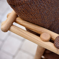 Brown woven fabric with a textured pattern, complemented by natural wood accents for a rustic look.