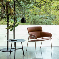 Brown upholstered chair with sleek lines and a minimalist design, complemented by a black side table. Modern aesthetic.
