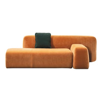 Modern orange sofa with a plush texture and green accent pillow, featuring a sleek, minimalist design.
