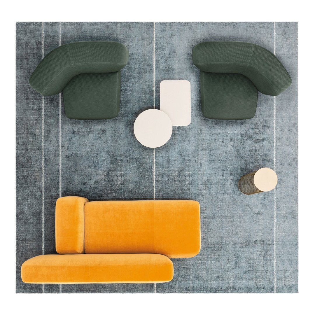 Colorful modern living room setup featuring green armchairs, orange sofa, white and round coffee table on blue patterned rug.