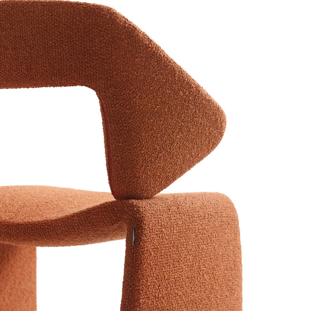 Rust-orange textured upholstery with a geometric pattern in a modern abstract design.