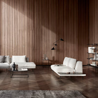 Modern white sofas on a textured wooden floor, with warm brown tones and soft gray accents in a minimalist setting.