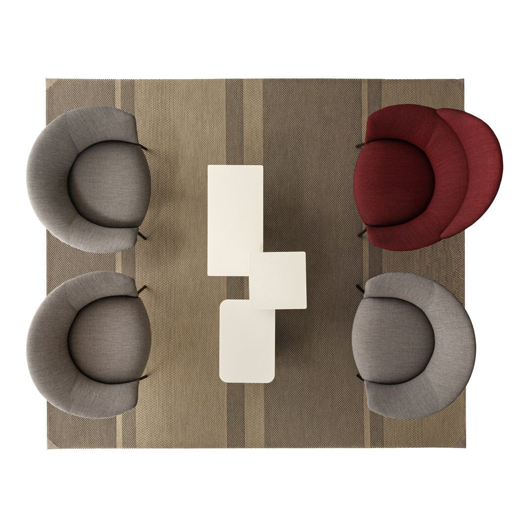 "Modern seating in grey and burgundy with a neutral striped rug, creating a stylish and inviting setting."