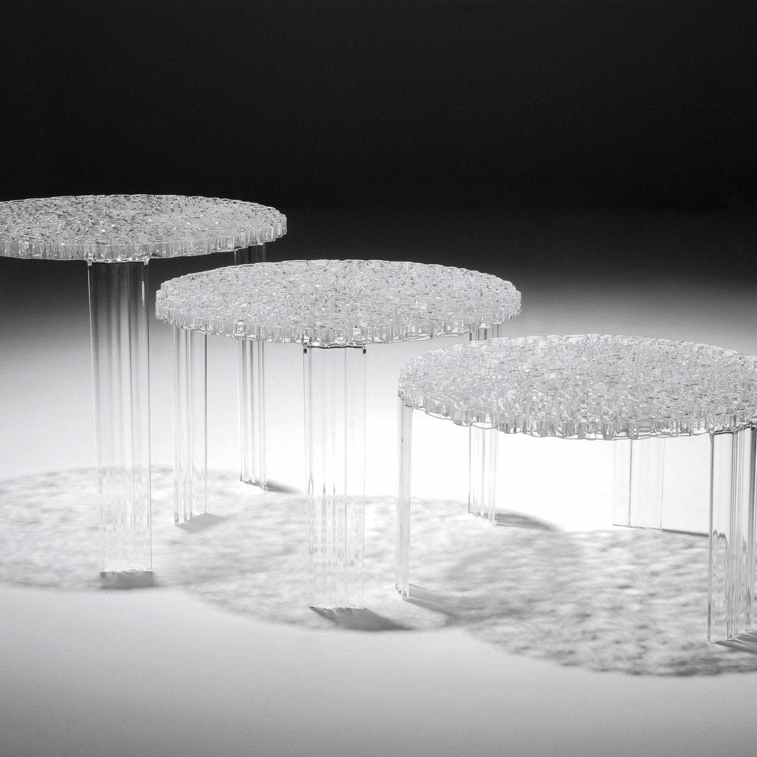 "Transparent acrylic nesting tables with textured, round tops and sleek legs, featuring a subtle shimmering pattern."
