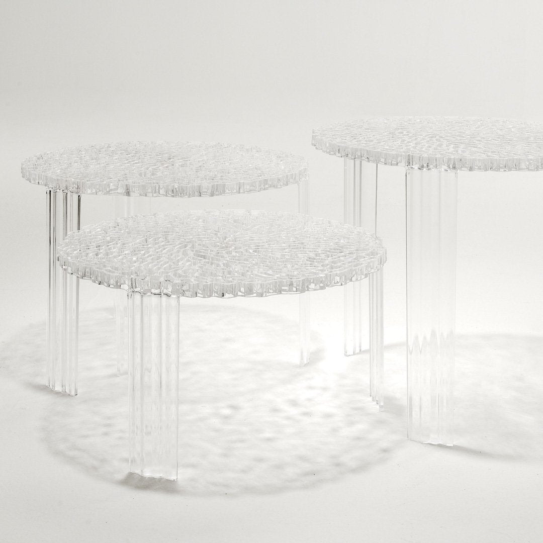 Three transparent, round side tables with a textured, bubble-like surface and clear, slender legs. Perfect for modern decor.