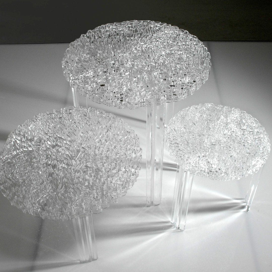 Three clear, textured glass side tables with intricate patterns, creating a modern, elegant look.