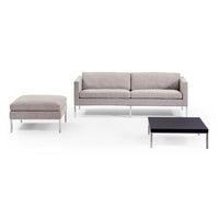 Gray fabric sofa with sleek silver legs, matching gray ottoman, and a modern black coffee table. Ideal for contemporary decor.