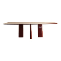 Red and beige modern dining table with a smooth, curved top and bold, geometric legs. Perfect for contemporary decor.