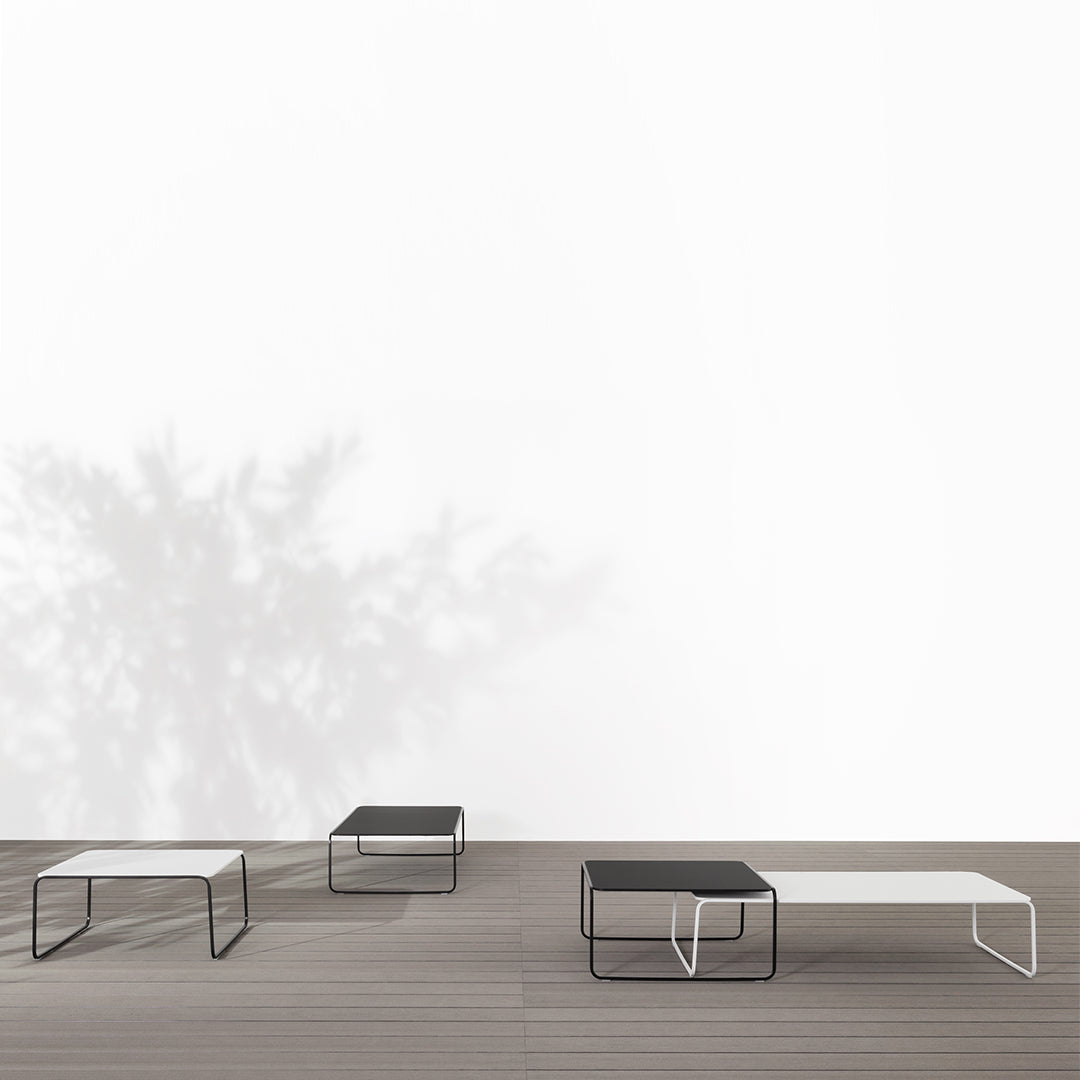 Minimalist coffee tables in black and white with clean lines and geometric patterns, set against a light backdrop.