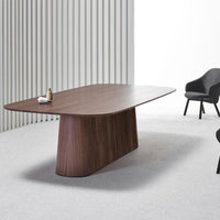 Rectangular walnut dining table with a smooth wood finish, set against a light gray carpet and white backdrop.