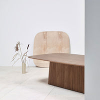 Modern wooden table in rich walnut finish; soft beige backdrop with natural patterns and textures. Minimalist design.