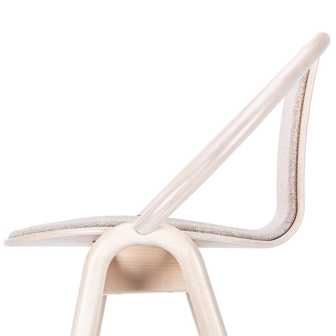 Light beige chair with a smooth curved backrest and subtle textured fabric pattern. Elegant and minimalistic design.