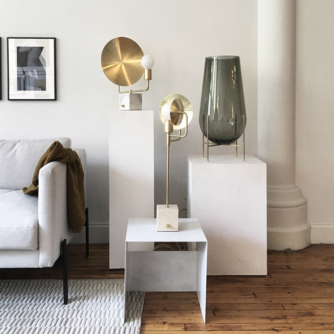 Gold and gray decorative lamps paired with white and natural wood elements in a modern living space.