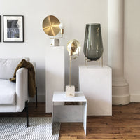 Gold and gray decorative lamps paired with white and natural wood elements in a modern living space.