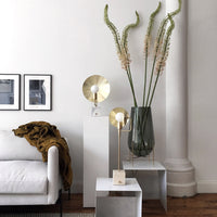 "Elegant brass lamp with a minimalist design, paired with a sleek gray and white decorative table."
