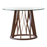 Modern round table with a clear glass top and a geometric brown wooden base pattern.