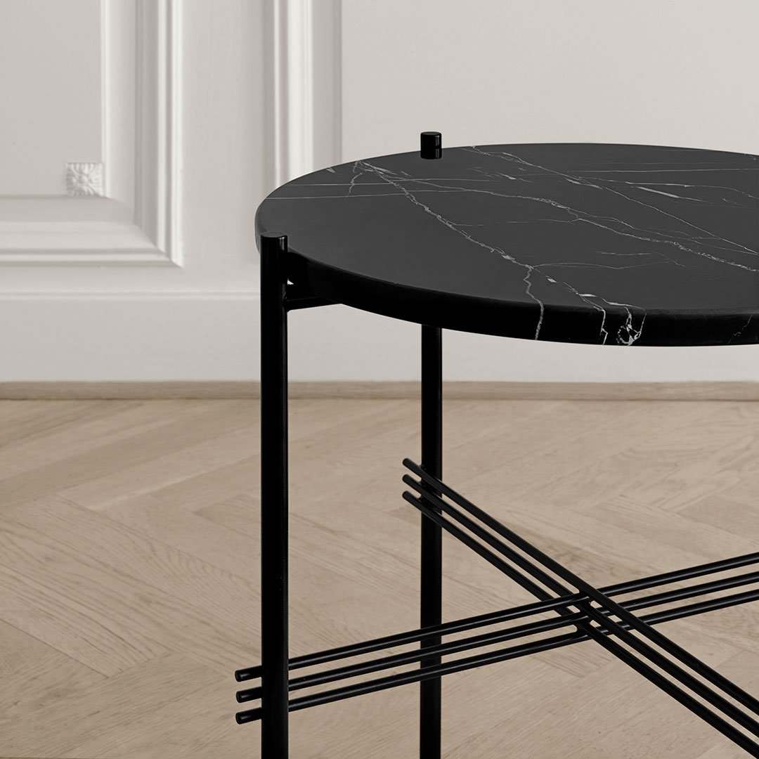 Black round marble tabletop with white veining on a sleek black metal frame. Modern and elegant design.