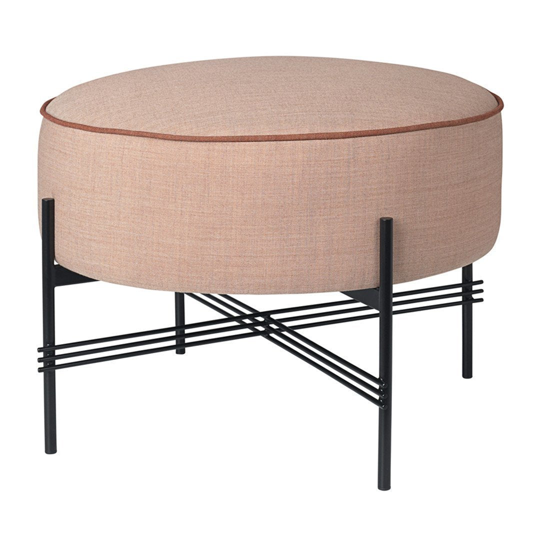 Round pink ottoman with a sleek black metal base and minimalist cross-pattern legs. Elegant and modern design.