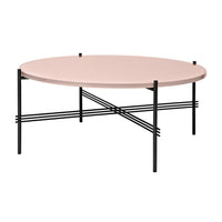 Round coffee table with a soft pink top and sleek black legs, featuring a minimalist crossbar design.