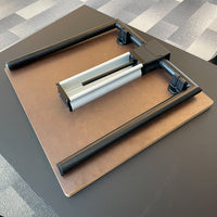 Black and silver adjustable table mount with a sleek brown wooden surface, showcasing modern, minimalist design.