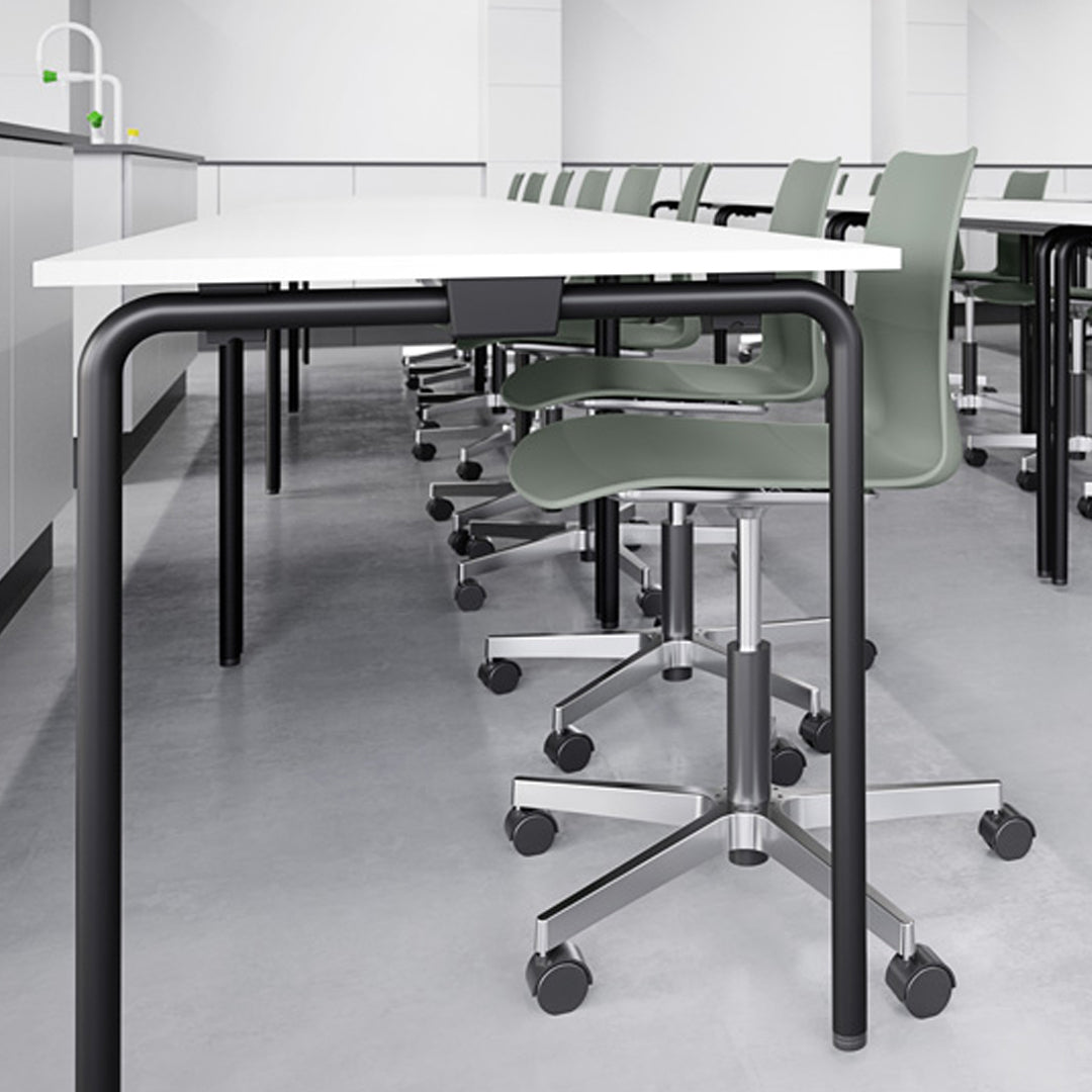 Modern gray and white classroom setting featuring sleek black and green patterned chairs.