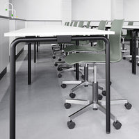 Modern gray and white classroom setting featuring sleek black and green patterned chairs.