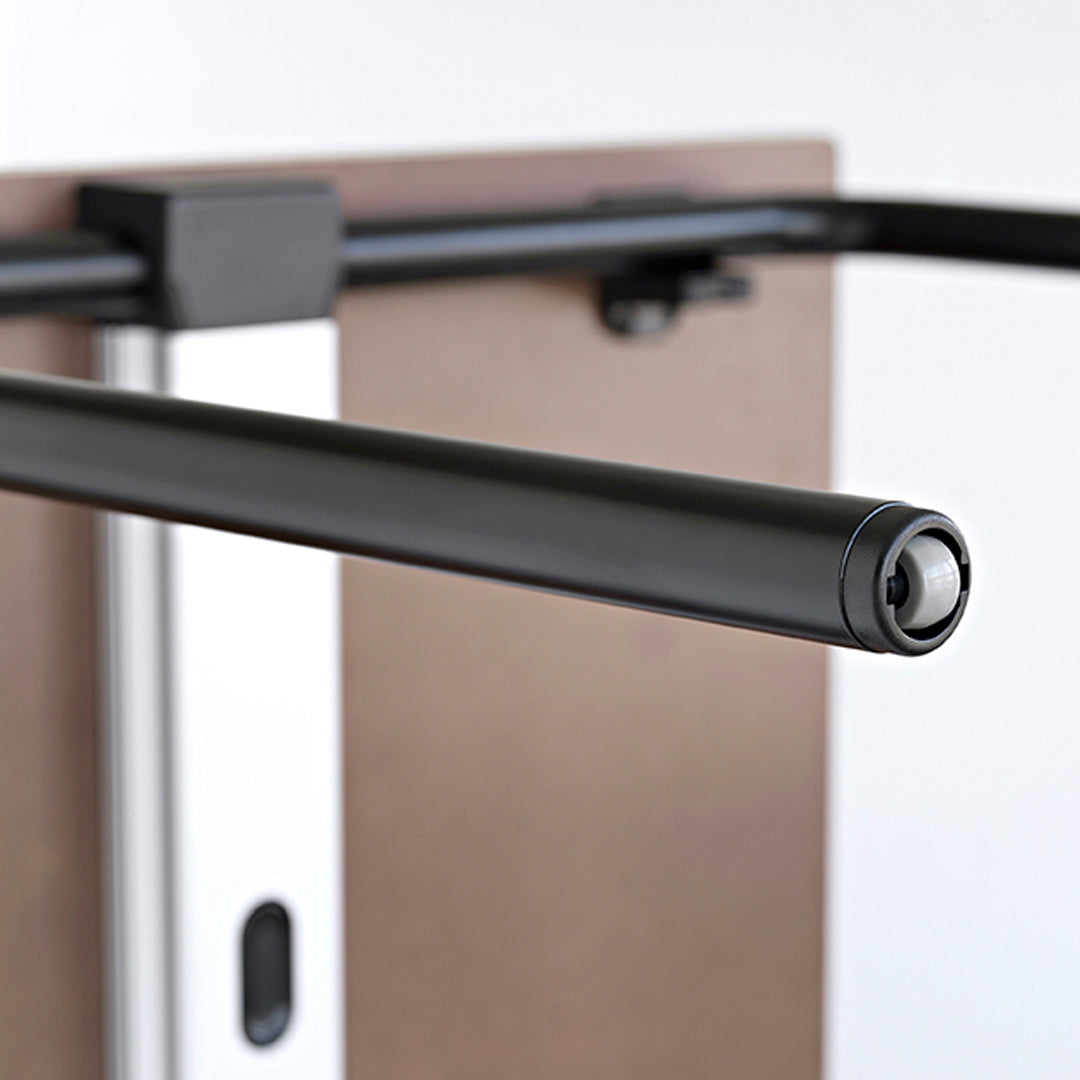 Black metal pull-up bar with a sleek finish, set against a neutral brown background. Perfect for home workouts.
