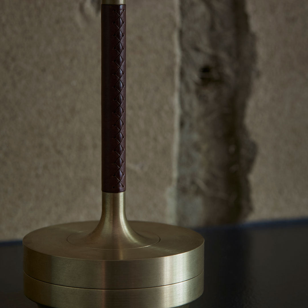 Braided burgundy leather handle on a sleek brass base, adding elegance to any decor.